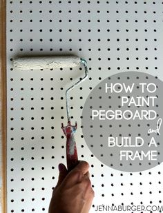 someone is painting the pegboard with white paint and holding a brush in their hand