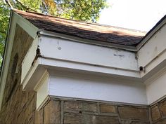 the corner of an old brick building with wood shingles on it's roof