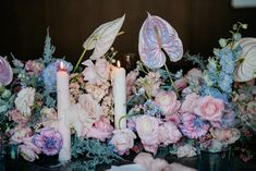 flowers and candles are arranged on a table