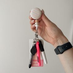 a hand holding a keychain with keys attached to it