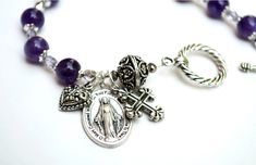 Searching for a meaningful gift? This stunning Miraculous Medal semi precious gemstone rosary bracelet with Memorare prayer card might be just what you were looking for, not to mention what a beautiful way to witness your faith and pray with anytime. Thoughtfully handcrafted, my miraculous medal rosary bracelet consists of genuine amethyst semi precious stones, each trimmed with faceted, fire-polished Preciosa Czech glass. The Our Father focal bead is a detailed sterling silver plated bali bead. Spiritual Healing Jewelry With Miraculous Medal, Silver Rosary Bracelet With Gemstone Beads, Silver Rosary Bracelet With Gemstone Beads As Gift, Nickel-free Spiritual Rosary Bracelet Gift, Spiritual Bracelets With Miraculous Medal As Gift, Spiritual Beaded Bracelets With Miraculous Medal, Handmade Spiritual Purple Rosary Bracelet, Silver Rosary Bracelet With Natural Stones As Gift, Spiritual Nickel-free Crystal Bracelet As Gift