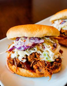 two pulled pork sandwiches on a white plate