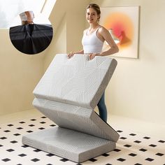 a woman standing next to a bed in a room with black and white checkered flooring