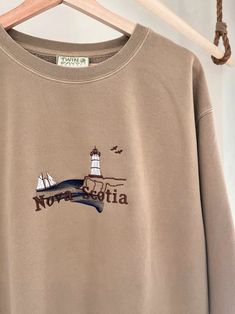 We sell primarily on our website. TwinRavenCo where we offer free shipping options and more colours.  Experience the charm of Nova Scotia, Canada in this vintage style crewneck. Featuring a mesmerizing ocean view and a tribute to the iconic Bluenose ship. 🍁 These crews are incredibly comfy, and unisex for that perfect oversized fit. Embroidered with the highest quality threads. Check out our socials for discounts, new releases, and to see how we run our shop: TwinRavenCo Embroidery stabilizer i Vintage Embroidered Logo Crew Neck Top, Vintage Crew Neck Top With Embroidered Logo, Vintage Long Sleeve Sweatshirt With Letter Embroidery, Vintage Crew Neck Top With Embroidered Graphics, Vintage Long Sleeve Tops With Embroidered Text, Vintage Crew Neck Sweatshirt With Embroidered Logo, Vintage Long Sleeve Tops With Letter Embroidery, Vintage Cotton Tops With Letter Embroidery, Vintage Embroidered Crew Sweatshirt