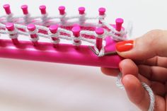 a woman holding a pink and white comb with red tips on it's end