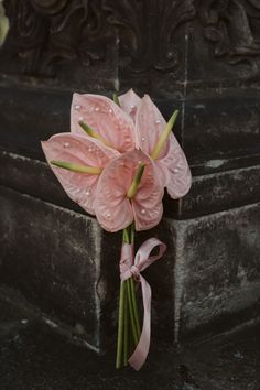 a bouquet of pink flowers sitting on top of a grave