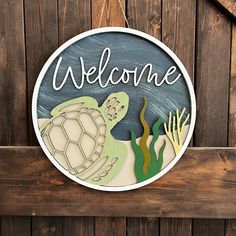 a welcome sign hanging on the side of a wooden fence with seaweed and turtle