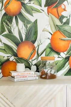 there is a shelf with books and oranges on it