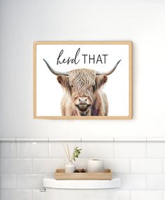 a white bathroom with a cow on the wall and a sign that says read that