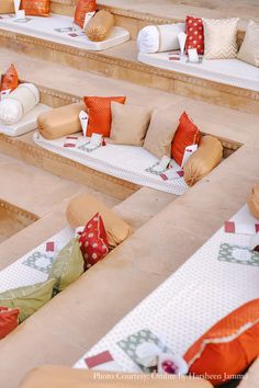 rows of couches with decorative pillows on them in an outdoor seating area for people to sit and relax