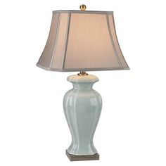 a white lamp with a beige shade on it