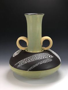 a black and green vase sitting on top of a table