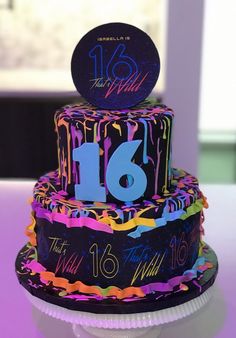 a colorful birthday cake with the number sixteen on it's top and icing sprinkles