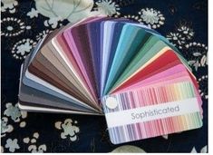 an assortment of color swatches on top of a blue table cloth with white flowers