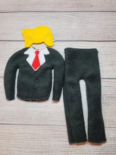 the doll is wearing a suit and tie with a yellow headband on it's head