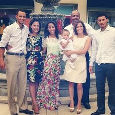 a group of people standing next to each other in front of a fountain and building