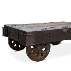 an old wooden cart with metal wheels and holes on the front, sitting on a white surface