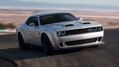 a silver sports car driving down a road