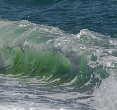 a large green wave in the middle of the ocean