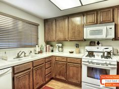 a kitchen with wooden cabinets and white appliances