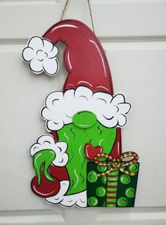 a door hanger with a grino face and presents hanging from it's side