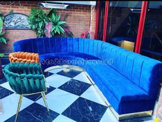 a blue couch sitting on top of a black and white checkered floor next to a green chair