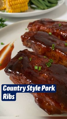 two ribs covered in bbq sauce on a white plate with green beans and corn