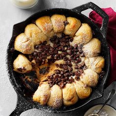 a cast iron skillet filled with croissants and raisins