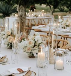 the table is set with white flowers and candles