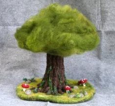 a small green tree sitting on top of a lush green field