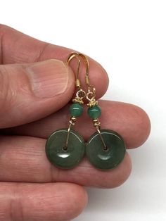 A pair of dangling earrings with a beautiful dark green jade disc safety buckles (平安扣), complemented by green aventurine beads.  The two dark green jade discs are small safety buckles. The Chinese safety buckle (平安扣) is shaped like a coin. The Chinese believed that money brought luck and safety, but wearing a coin was not attractive, so the lucky buckle was designed with materials like jade and agate to wear coins on their person. - made with jade discs, aventurine beads, gold-plated sterling si Aventurine Dangle Earrings For Gift, Green Aventurine Dangle Earrings, Green Aventurine Drop Earrings, Natural Stone Jade Dangle Earrings, Pierced Jade Dangle Earrings, Jade Dangle Earrings For Pierced Ears, Jade Earrings With Ear Wire For May Birthstone, Dark Green Round Jade Jewelry, Handmade Dark Green Jade Jewelry