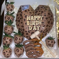 a birthday cake in the shape of a heart with strawberries and pretzels