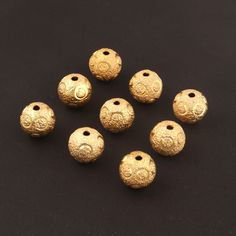 six gold bead caps with designs on them