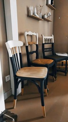 three wooden chairs sitting next to each other in a room