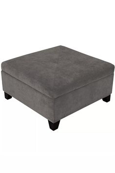 a grey ottoman sitting on top of a white floor