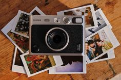 a camera sitting on top of a wooden table covered in pictures and sticker sheets