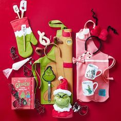 an assortment of items from the grinch movie are displayed on a red tablecloth