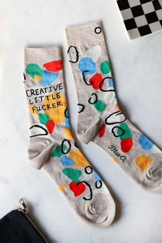 Celebrate his artistic side with the Creative Little Fucker Mens Crew Socks. These funny socks ensure his sock game is far from boring and introduce a pop of colour to any outfit. A fabulous gift for any occasion, from Secret Santa to birthdays or the Christmas stocking, the colourful crew socks are guaranteed to lift the mood and make any day a better day – even Mondays. True to the “Creative Little Fucker” tagline at the top of the socks, the neutral woven background is lifted with black squiggles and dollops of colour in red, green, blue and yellow to evoke a paint palette. A piece of art for your feet, these novelty socks are perfect for any creative man in your life. -Neutral crew socks for men with a colour pop pattern- Fits men's UK sizes 7-12- Made from a soft combed cotton and nyl Blue Q Socks, Rockett St George, Blue Q, Mens Crew Socks, Sock Game, Charity Work, Quilted Bedspreads, Funny Socks, Better Day