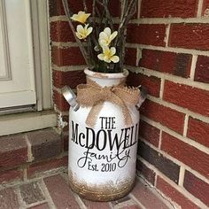 a vase with some flowers in it sitting on the side of a brick wall next to a door