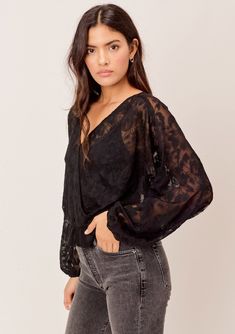 [Color: Black] A surplice front blouse in a floral embroidered lace. Featuring flattering voluminous dolman sleeves Feminine Blouse With Lace Sleeves And V-neck, Chic Lace V-neck Tops, V-neck Lace Top Blouse For Night Out, Spring V-neck Lace Top For Night Out, Feminine V-neck Lace Top For Fall, Lace V-neck Top, V-neck Lace Top For Date Night, Chic V-neck Lace Top For Fall, V-neck Lace Top For Night Out