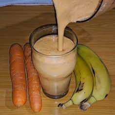 some carrots and bananas are next to a smoothie