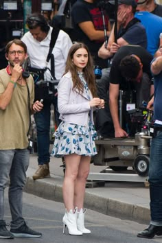 a woman standing in front of a camera on the street