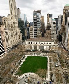 an aerial view of a large building in the middle of a city with lots of tall buildings