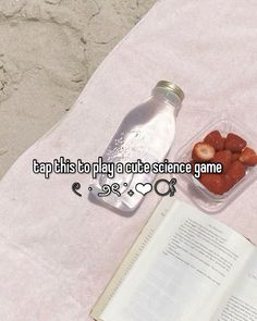 an open book sitting on top of a table next to a plastic container filled with strawberries