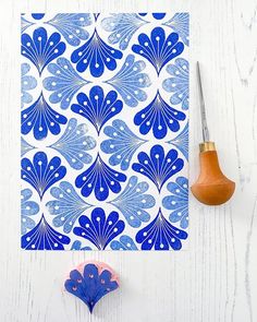 a blue and white paper with an intricate design on it next to a rubber stamp