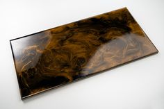 a brown and black marbled object on a white surface