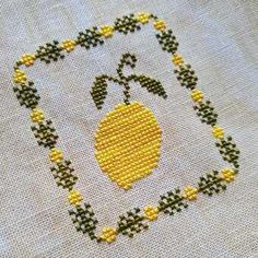 a cross stitch pattern with an apple and leaves on the bottom, in yellow thread