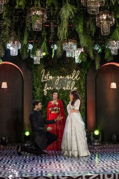 the bride and groom are getting married in front of an archway decorated with greenery