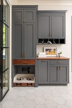 a kitchen with gray cabinets and wooden counter tops