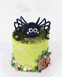 a green cake with a spider on top